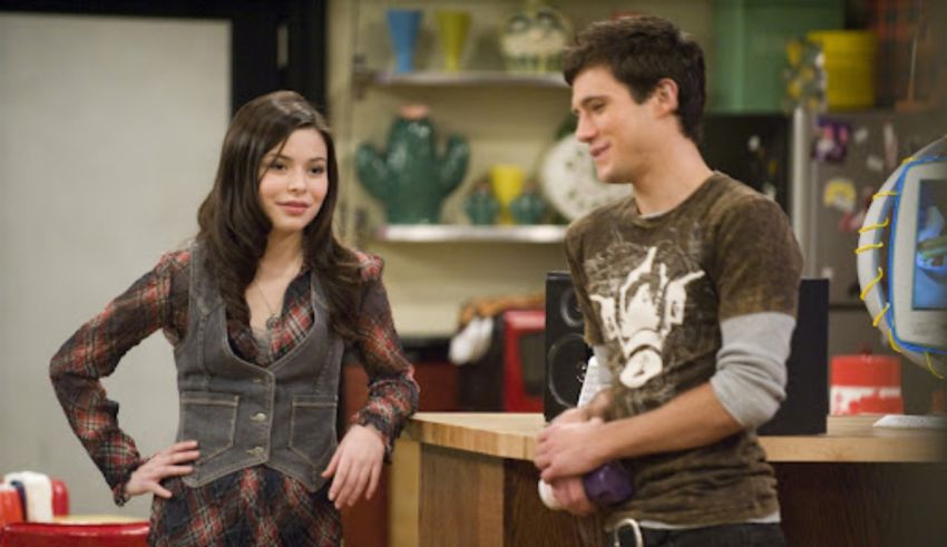 A man and woman standing next to each other in a kitchen.
