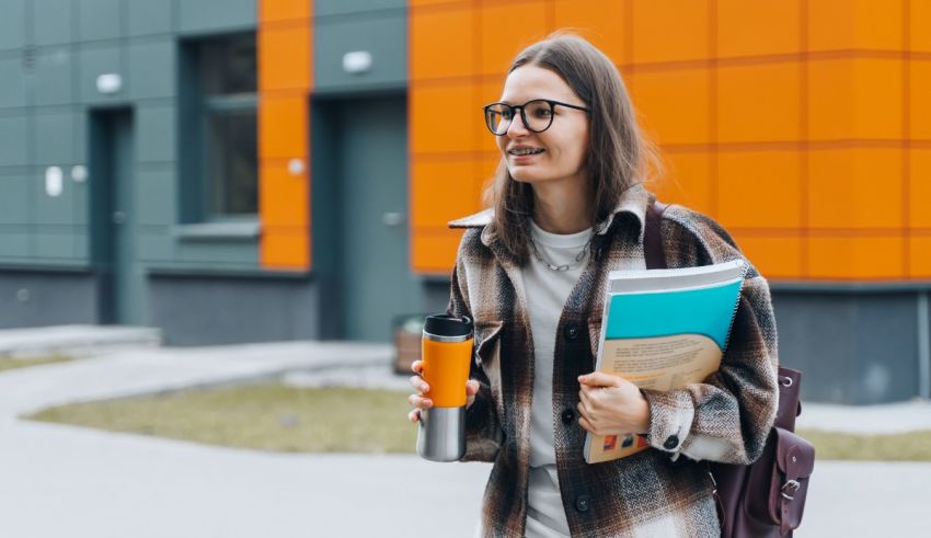 A young woman wearing glasses and carrying a backpack is walking down the street.
