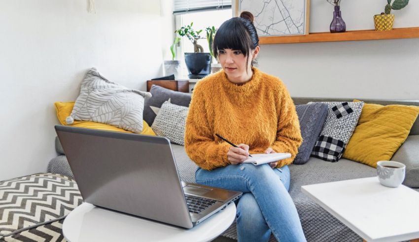 A woman sitting on a couch with a laptop.