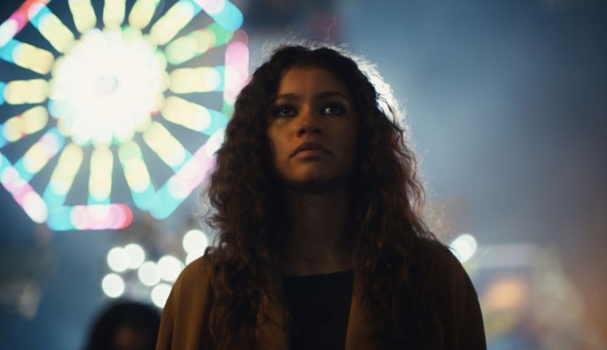 A young woman standing in front of a ferris wheel.