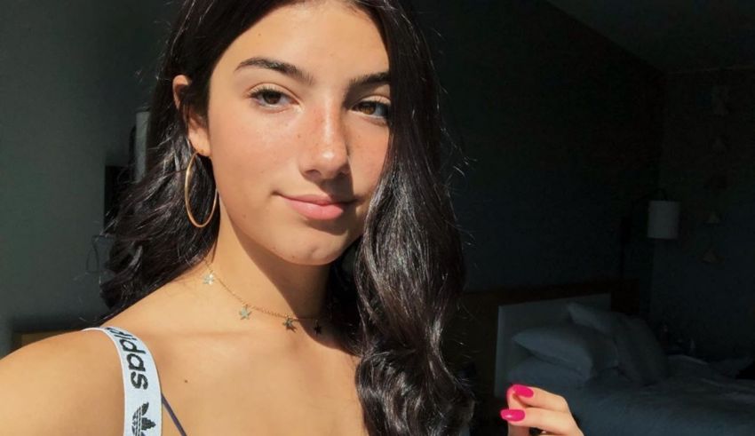 A young woman wearing a black tank top and a pair of hoop earrings.
