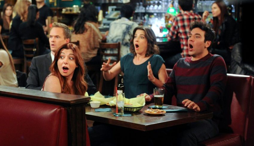 A group of people sitting at a table in a bar.
