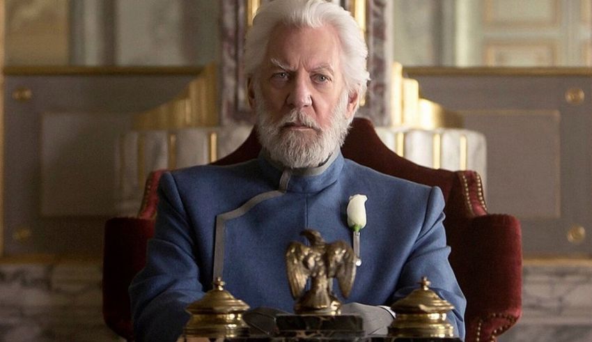 A man in a blue suit sitting in a chair.