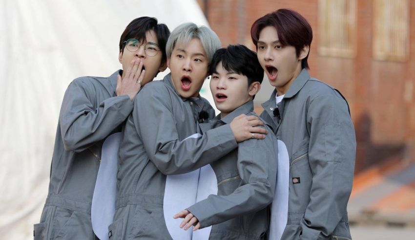 Four asian men in grey uniforms posing for a picture.