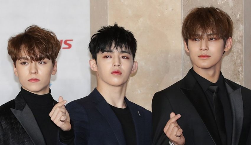 Three asian boys posing on a red carpet.