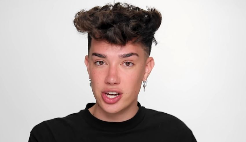 A young man with curly hair is looking at the camera.