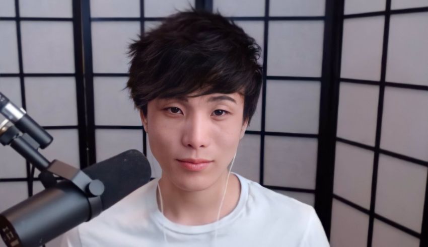 A young asian man in front of a microphone.