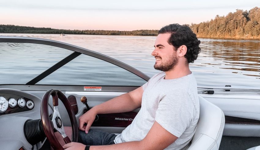 A man sitting in the driver's seat of a boat.