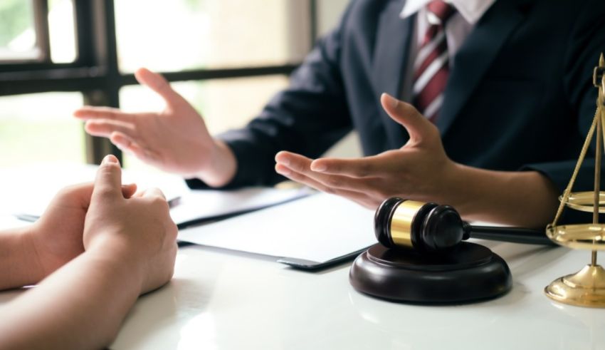 A man in a suit is talking to a woman in a courtroom.