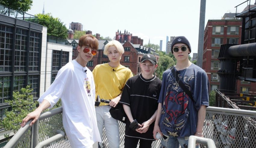 Four young men posing for a picture on a bridge.