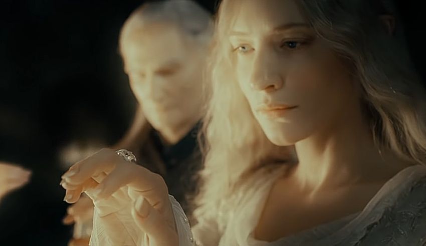 A woman is holding a ring in front of a man.