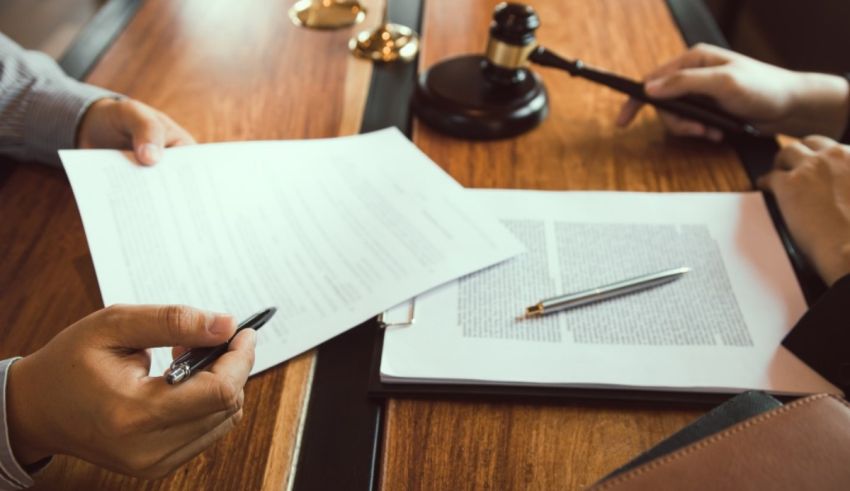 Two people signing a document at a table.
