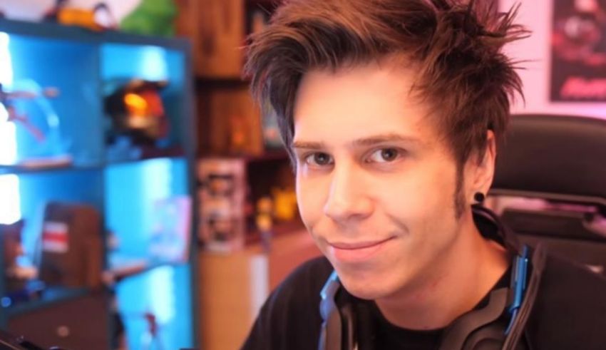 A young man with headphones in front of a desk.