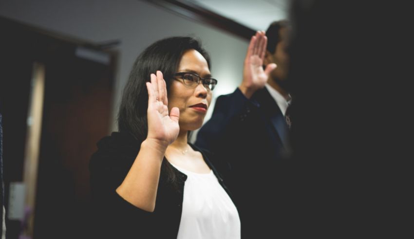 A woman is staking her hands in front of a group of people.