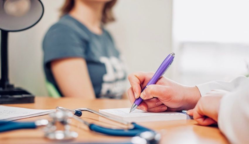 A doctor writing on a notepad with a stethoscope.