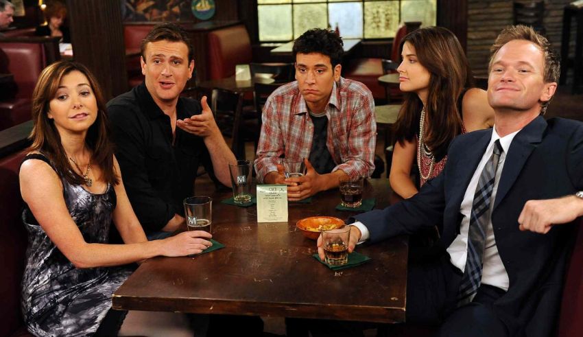 A group of people sitting around a table in a bar.