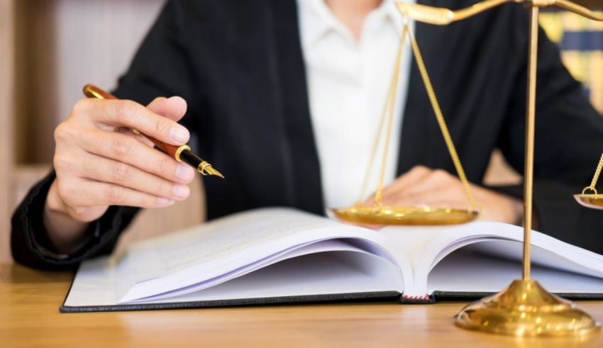 A woman in a suit is holding a scale and a pen.