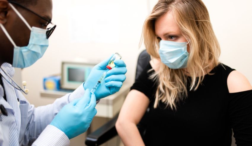 A doctor is giving a woman a shot.