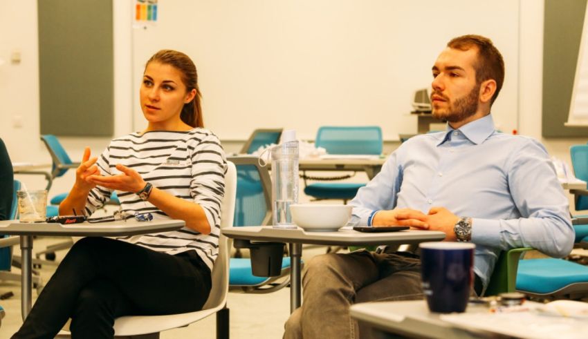A group of people sitting at desks in a classroom.