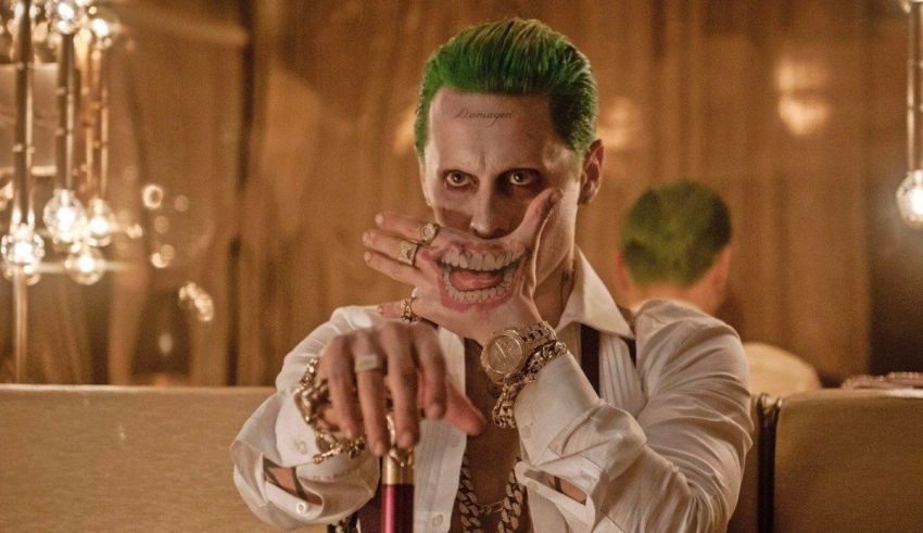 The joker is sitting on a couch with green hair.