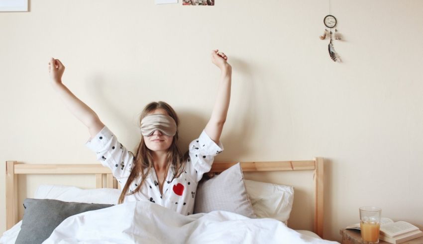 A woman in a bed with blindfold covering her eyes.