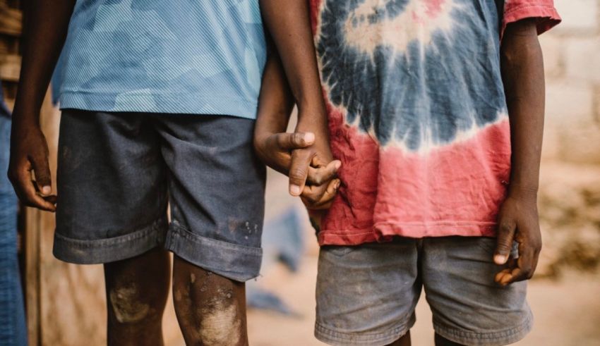 Two boys holding hands in front of a building.