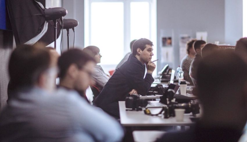 A group of people sitting at desks in an office.