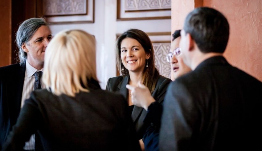 A group of business people talking to each other.