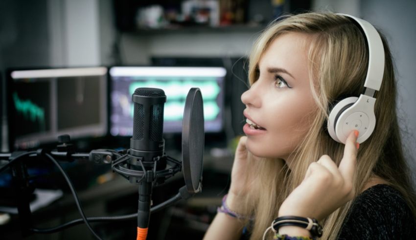 A woman wearing headphones in front of a microphone.
