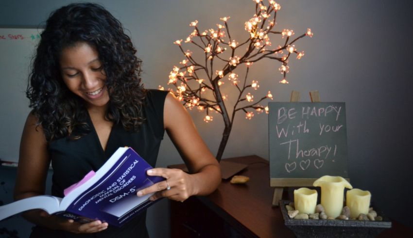 A woman reading a book in front of candles.