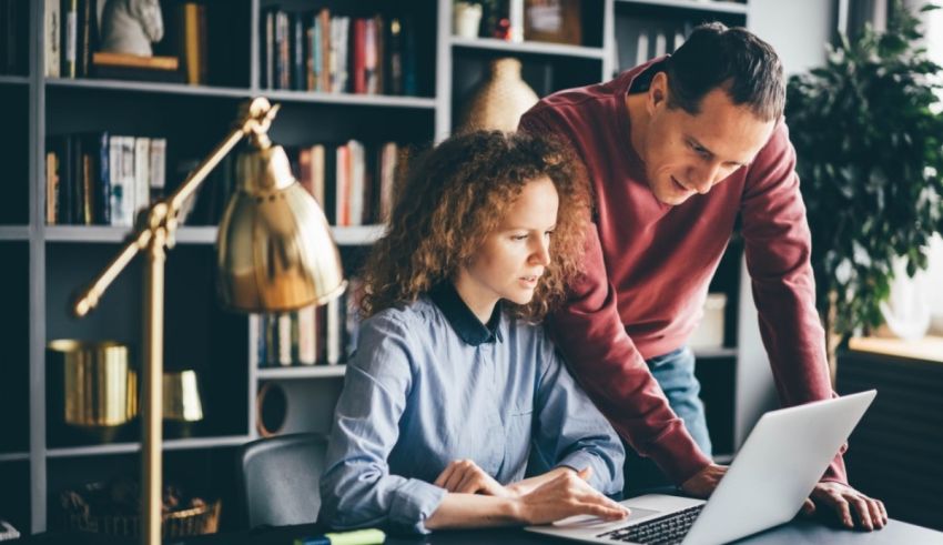 A man and woman looking at a laptop.
