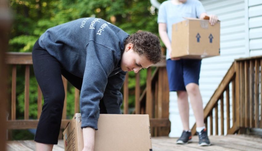 Two people moving boxes on a deck.
