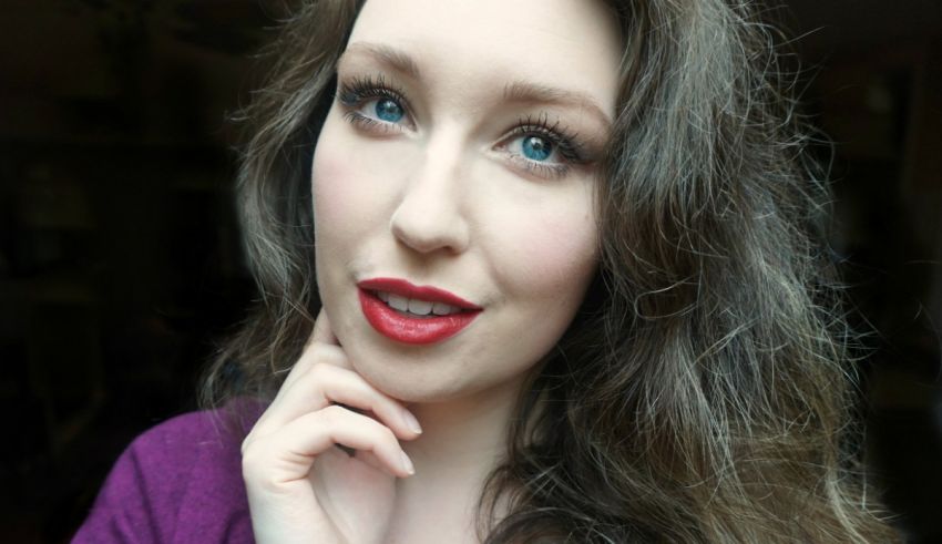 A woman with long hair and red lipstick posing for a photo.