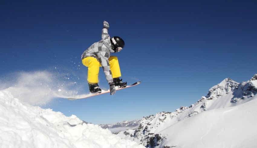 A snowboarder doing a jump on a snowy mountain.