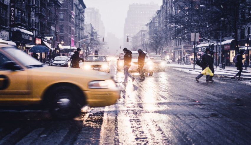 A yellow taxi driving down a city street.