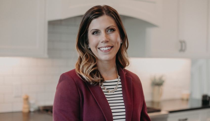 A woman in a striped blazer standing in a kitchen.