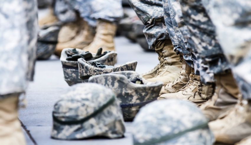 A line of military boots lined up on a sidewalk.