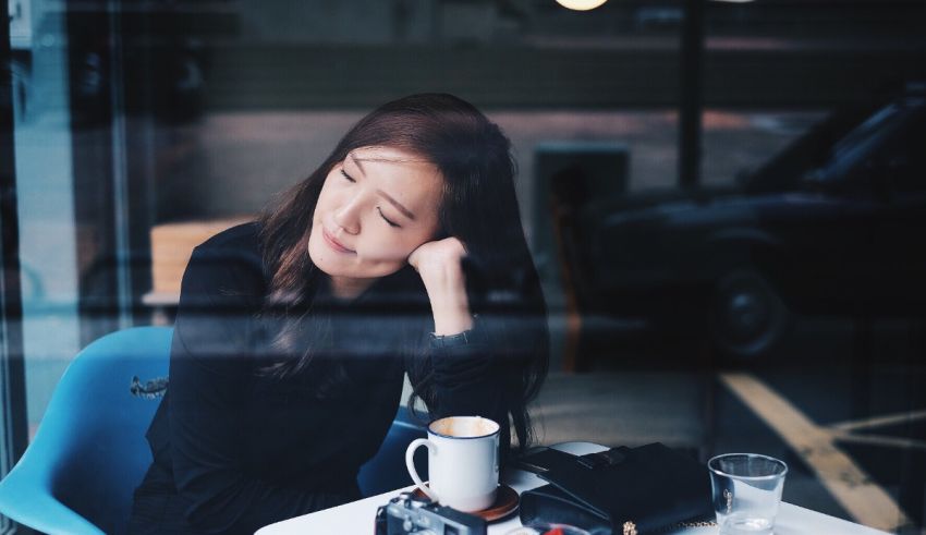 A woman sitting at a table with a cup of coffee.