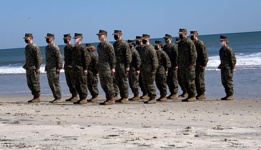 A group of marines standing on a beach.