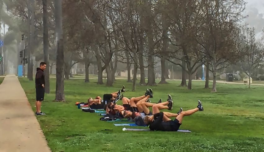 A group of people laying on the ground in a park.