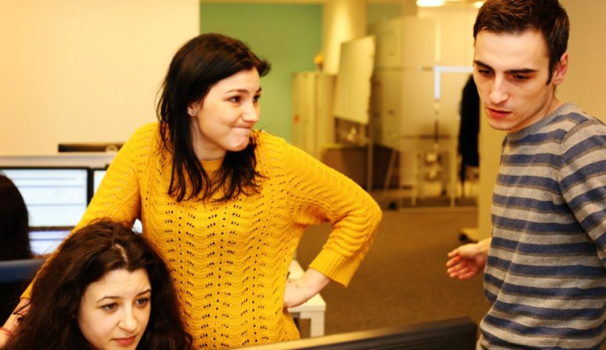 A group of people looking at a computer screen.