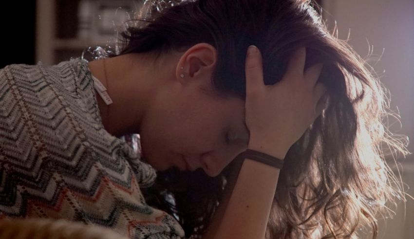 A woman is holding her head in her hands.