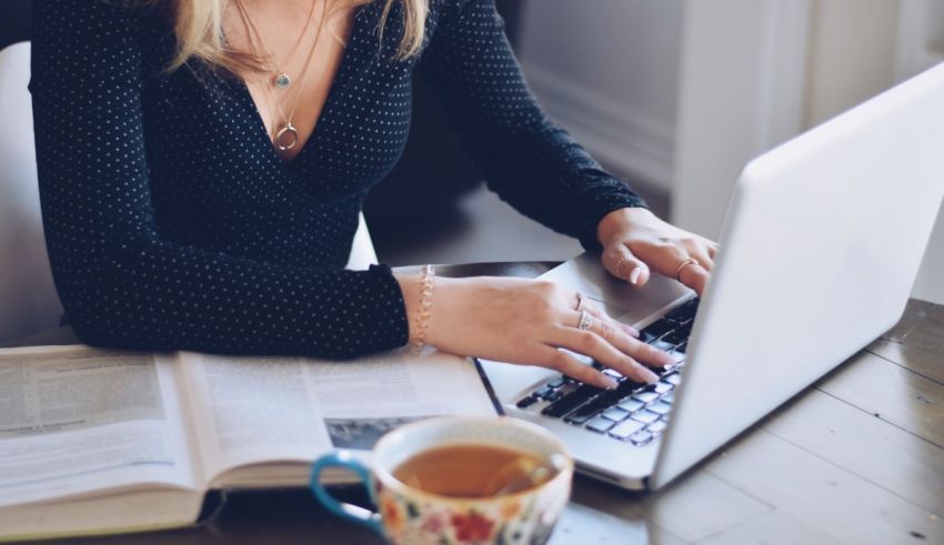 A woman working on her laptop with a cup of coffee.