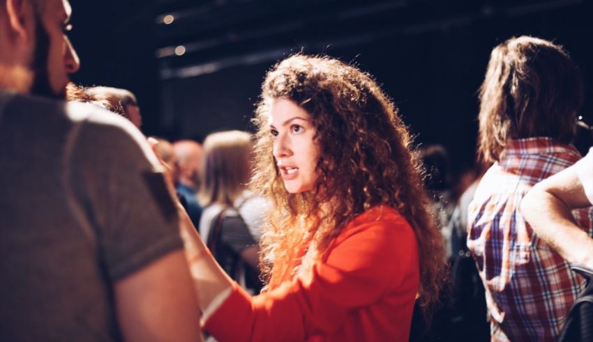 A woman talking to another woman in a crowd.