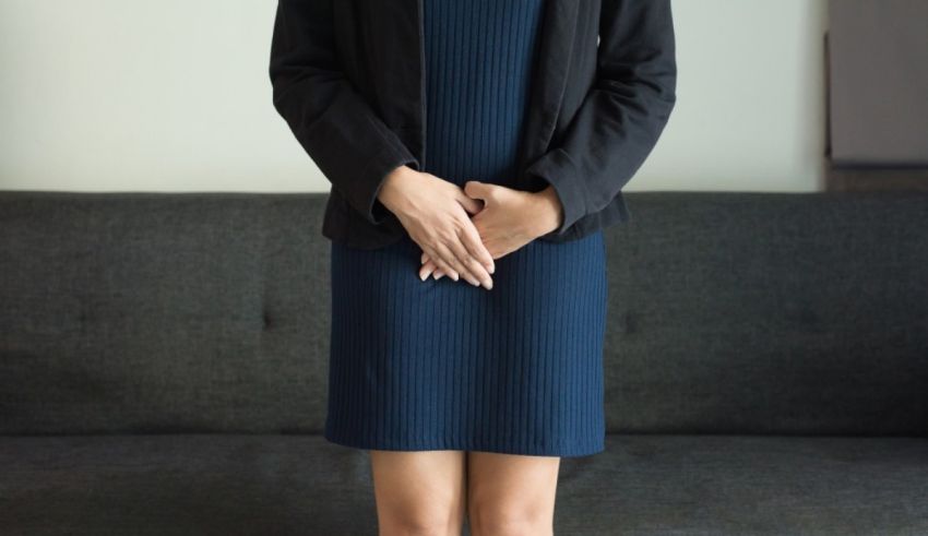 A young woman in a blue dress standing on a couch.