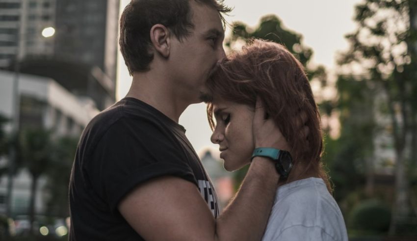 A man and woman hugging in front of a city.