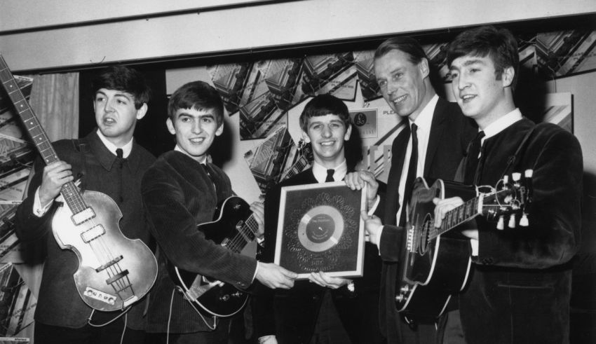 The beatles posing with their guitars.