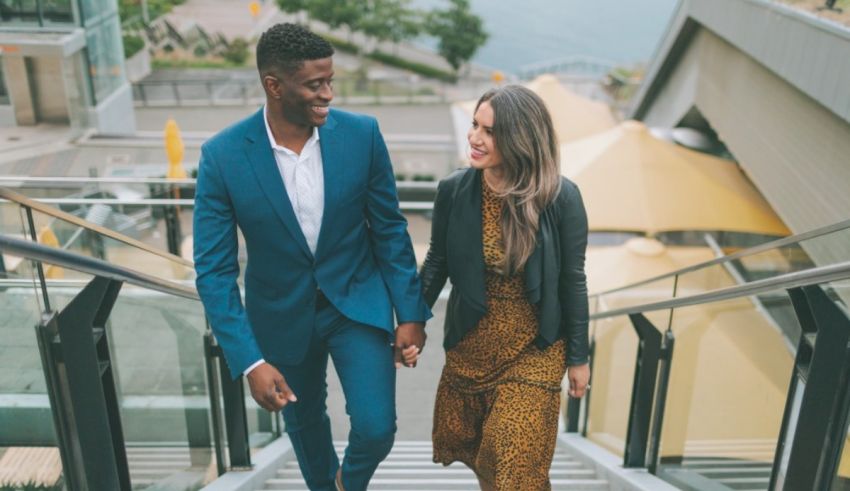 A man and woman walking down stairs on an engagement session in vancouver.