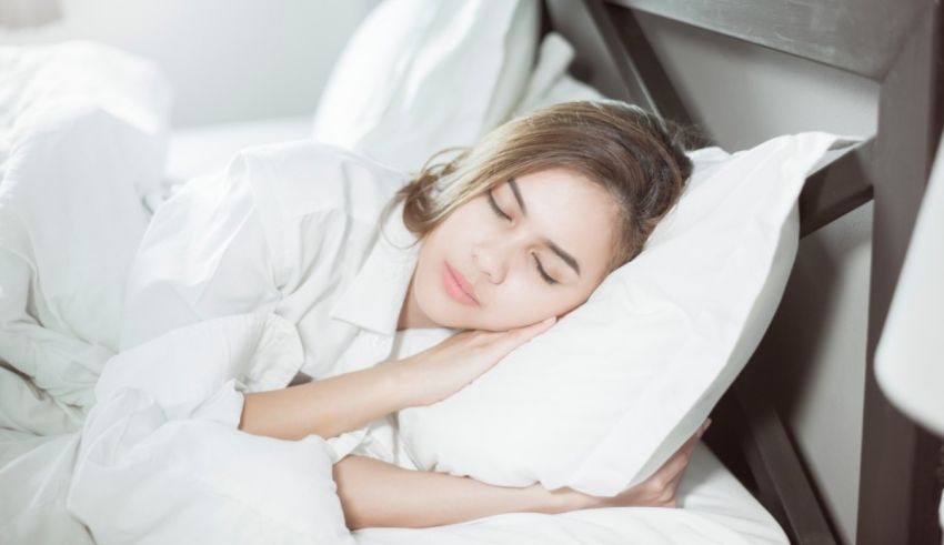 A woman sleeping in a white bed with a pillow.
