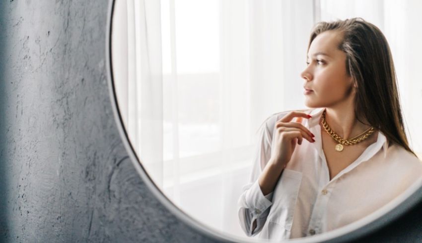 A woman is looking at herself in a mirror.